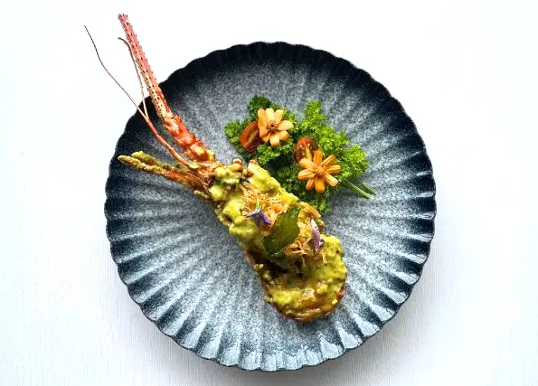Gourmet lobster tail with curry sauce and edible flowers for halal wedding catering in Kuala Lumpur